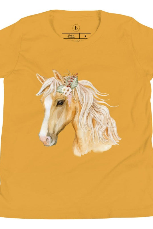 Embrace the equestrian vibe with our kids' shirt which features a majestic horse head adorned with a beautiful floral arrangement on its mane on a white shirt on a mustard colored shirt. 