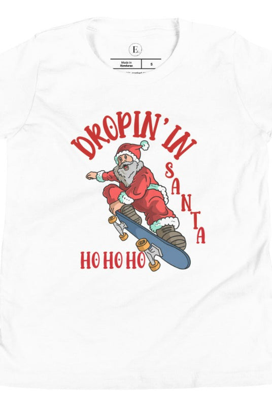 Get your kids in the holiday spirit with our unique, playful tee featuring Santa shredding on a skateboard with the phrase "Dropin' In Santa Ho Ho Ho." On a white shirt. 
